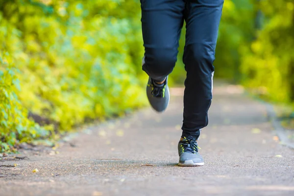 Close-up on shoe of athlete runner man feet running on road — Stock Photo, Image