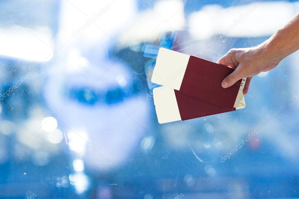 Closeup passports and boarding pass at airport indoor background aircraft