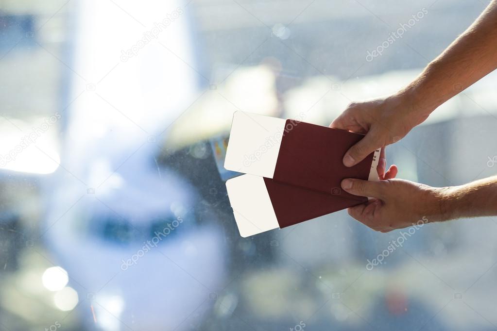 Closeup passports and boarding pass at airport indoor background aircraft