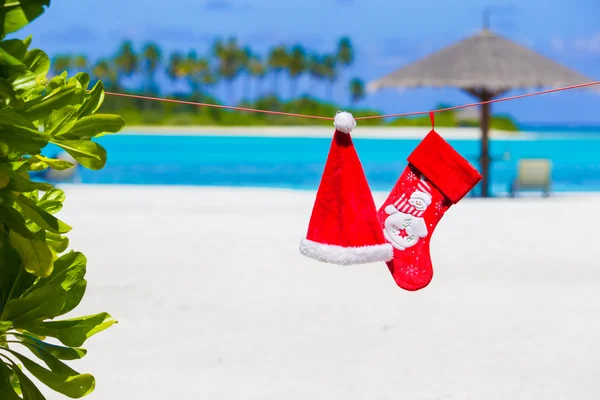 Topi Red Santa dan kaus kaki Natal di pantai — Stok Foto