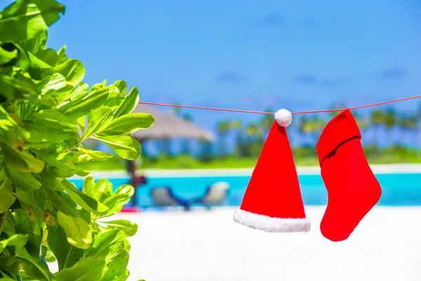 赤サンタ帽子と熱帯のビーチに掛かっているクリスマス ストッキング — ストック写真