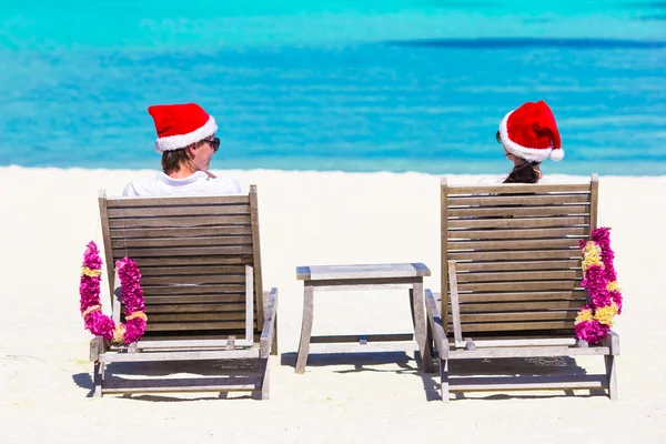 Giovane coppia a Santa cappelli relax sulla spiaggia durante le vacanze di Natale — Foto Stock