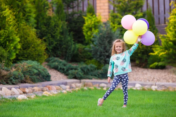 Happy little girl playing with balloons outdoors — Stock Photo, Image