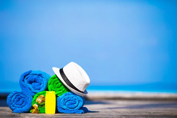 Conceito de acessórios de férias de praia e verão - close-up de toalhas coloridas, chapéu, óculos de natação e protetor solar — Fotografia de Stock