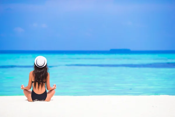 Mujer joven sentada en posición de yoga durante las vacaciones tropicales — Foto de Stock