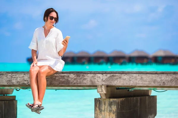 Jonge mooie vrouw op houten brug bij tropisch strand — Stockfoto