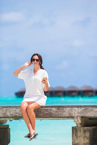 Ung vacker kvinna på träbro på tropical beach — Stockfoto