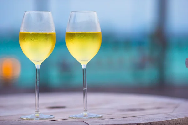 Dos copas de sabroso vino blanco al atardecer sobre una mesa de madera —  Fotos de Stock