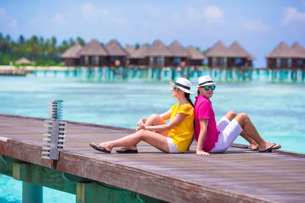 Young couple on beach jetty near water villa in honeymoon — Stock Photo, Image