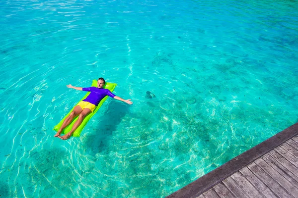 Young happy man relaxing on inflatable mattress in the sea — Stock Photo, Image