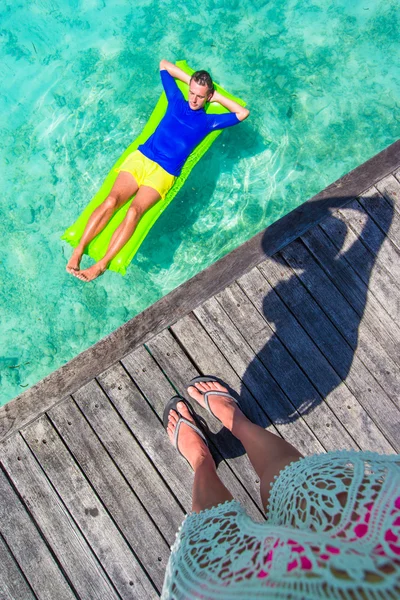 Junger glücklicher Mann entspannt sich auf aufblasbarer Matratze im Meer — Stockfoto