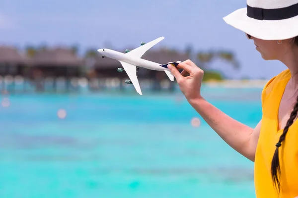 Kleines weißes Flugzeugmodell in weiblicher Hand Hintergrund des türkisfarbenen Meeres — Stockfoto