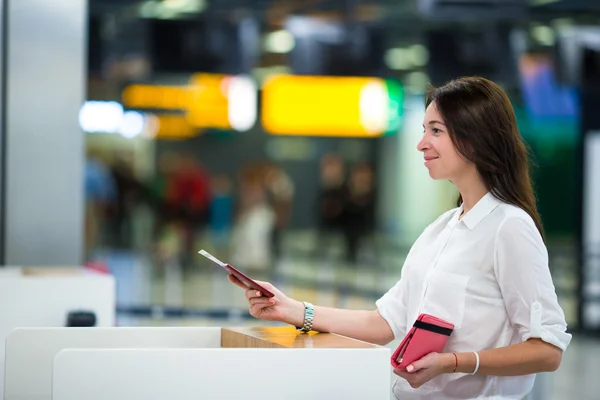 Mujer con pasaportes y tarjetas de embarque en la recepción del aeropuerto —  Fotos de Stock