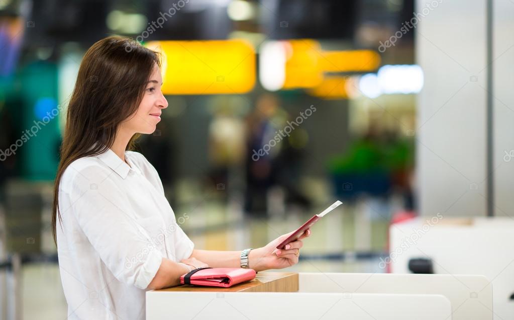Woman with passports and boarding passes at the front desk at airport