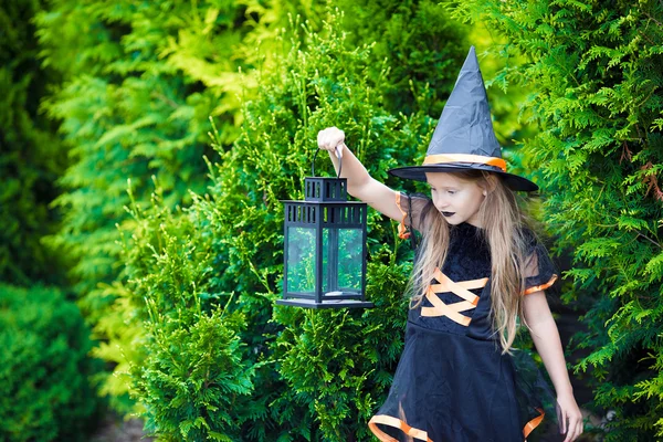 Rozkošná holčička v kostýmu čarodějnice s koštětem na Halloween venku — Stock fotografie
