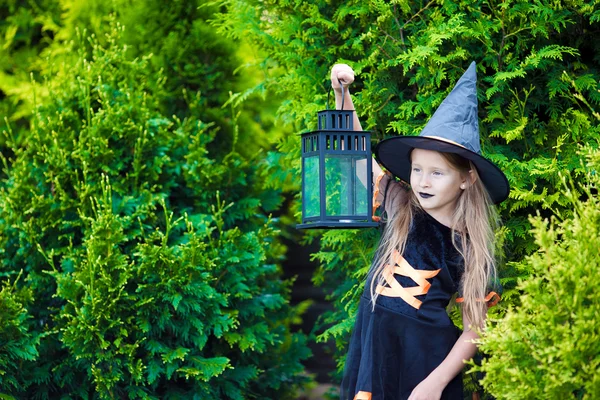 Adorabile bambina che indossa costume da strega con scopa su Halloween all'aperto — Foto Stock