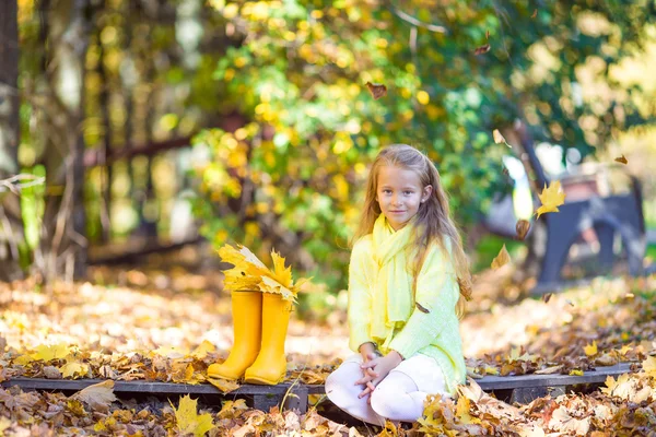 Adorable petite fille avec des feuilles d'érable jaune à l'extérieur à la belle journée d'automne — Photo