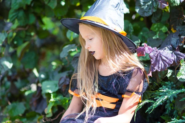 Adorable niña con traje de bruja con escoba en Halloween al aire libre. Truco o trato —  Fotos de Stock