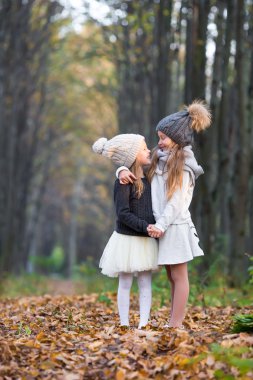 Güneşli bir sonbahar gününde küçük sevimli kızlar açık havada.