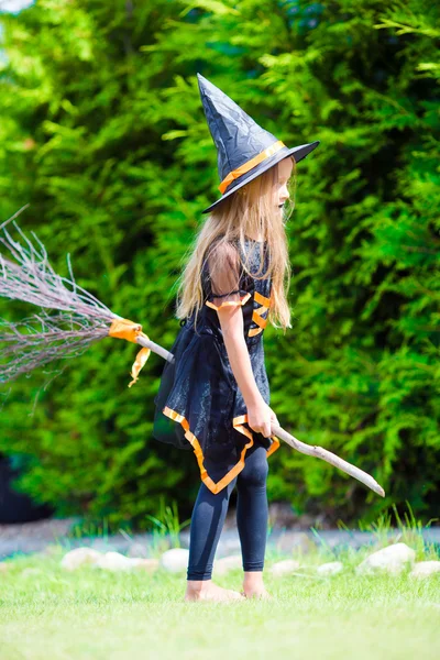 万圣节前夕，穿着女巫服装，戴着扫帚的可爱小女孩 — 图库照片