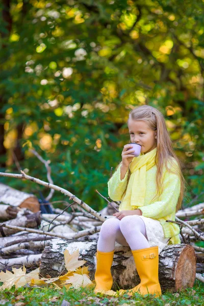 Entzückendes kleines Mädchen mit heißem Tee in der Thermoskanne im Freien an einem schönen Herbsttag — Stockfoto