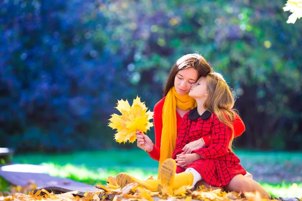 Adorable little girl with mother in autumn park outdoors — Stock Photo, Image