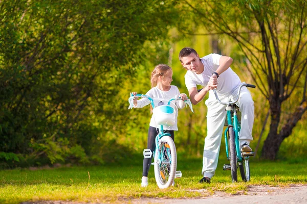 若い父親と夏の暖かい日に自転車に乗る少女 — ストック写真