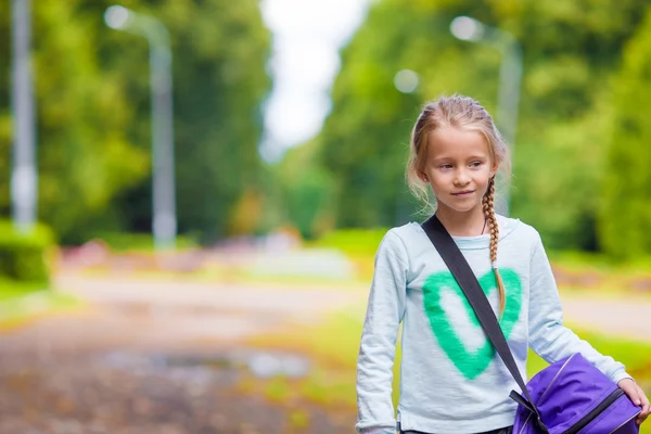Маленькая очаровательная девочка идет в спортзал со своей спортивной сумкой — стоковое фото
