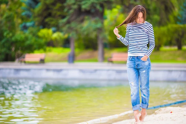 Young happy woman walking near the lake at warm autumn day — Stock Photo, Image