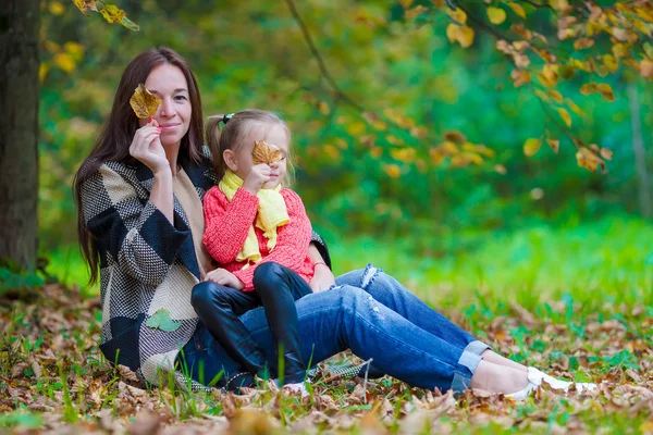 Adorable little girl with mother in autumn park outdoors — Stock Photo, Image