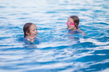 Dışarıda yüzme havuzunda oynayan sevimli küçük kızlar.