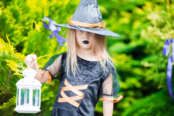 Imádnivaló intézmény kislány rajta boszorkány jelmez Halloween a szabadban. csokit vagy csalunk. — Stock Fotó