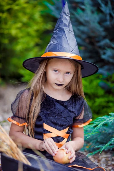 Portrait of cute little girl wearing witch costume with broom on Halloween — Stock Photo, Image