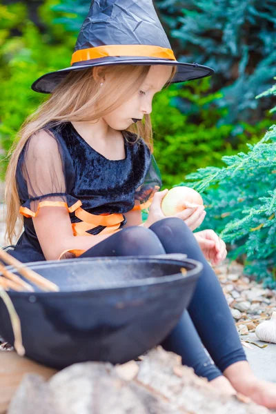 可爱的小女孩，在万圣节穿用扫帚的女巫服装 — 图库照片
