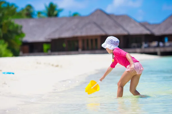 Rozkošný dívka si hraje s hračkami, beach během tropické dovolené — Stock fotografie