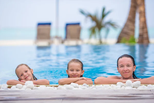 Little cute girl and happy mom enjoying vacation in outdoor swimming pool — Stock Photo, Image