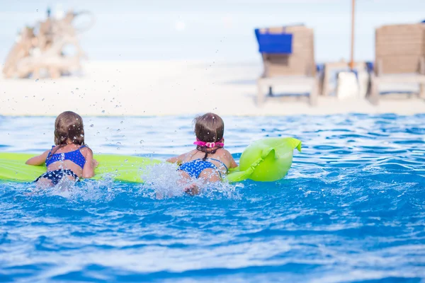 Schattige kleine meisjes spelen in het buitenzwembad op vakantie — Stockfoto