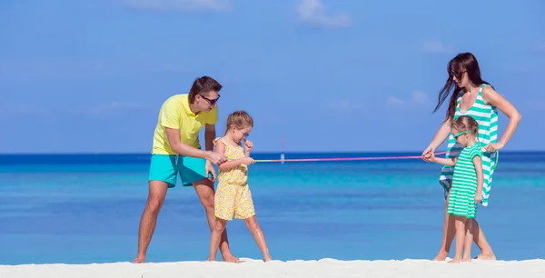 Lycklig familj att ha kul på vita stranden — Stockfoto