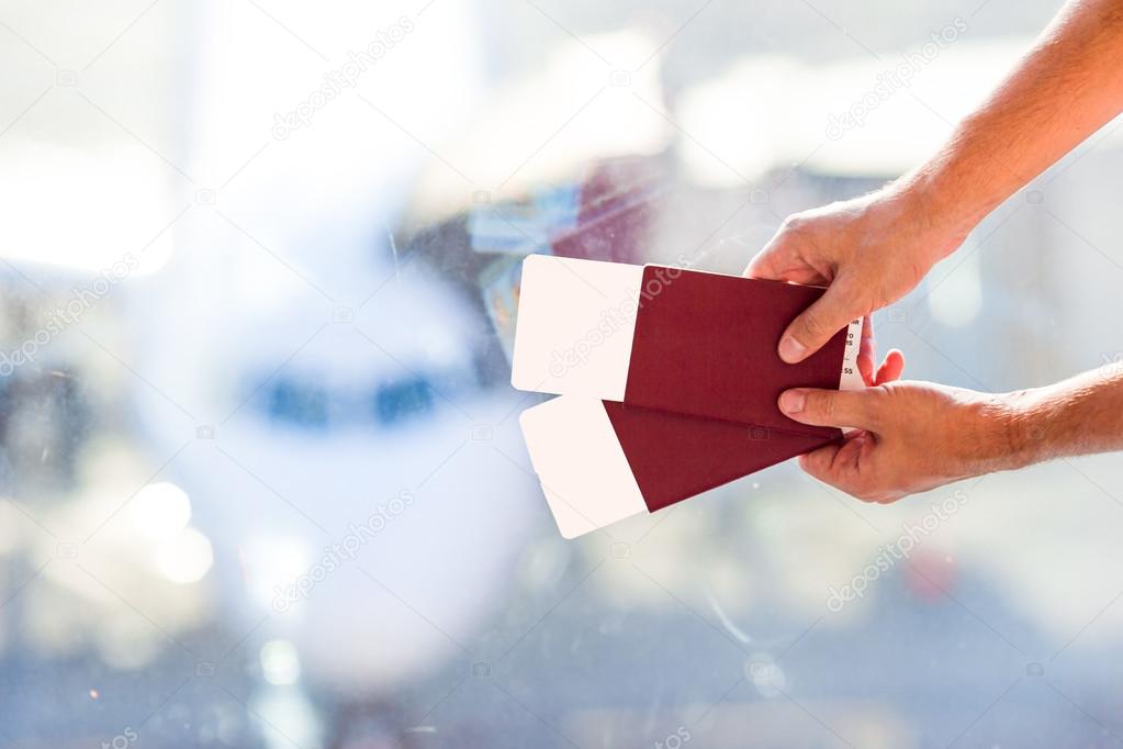 Closeup passports and boarding pass at airport indoor background airplane