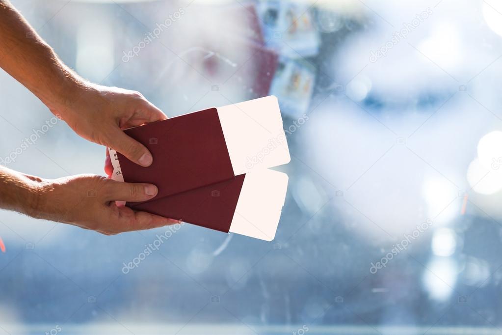 Closeup passports and boarding pass at airport indoor near big window