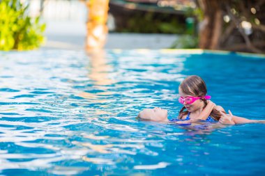 Sevimli küçük kızlar açık yüzme havuzunda tatil