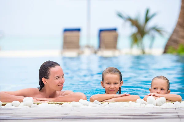 Adorable girl and happy mom enjoying vacation in outdoor swimming pool — Stock Photo, Image