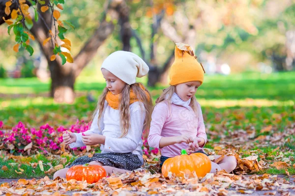 Αξιολάτρευτο κοριτσάκια με κολοκύθες σε εξωτερικούς χώρους σε όμορφη μέρα του φθινοπώρου. Κόλπο ή κέρασμα — Φωτογραφία Αρχείου
