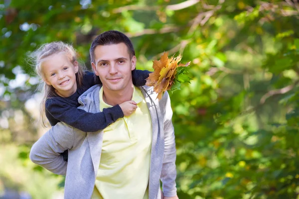 Kleines entzückendes Mädchen mit Papa im Herbstpark an warmen Tagen — Stockfoto