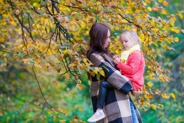 Bedårande liten flicka med mamma i höst park utomhus — Stockfoto