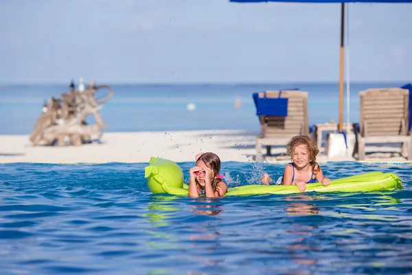 Adorable little girls in outdoor swimming pool on vacation — Stock Photo, Image