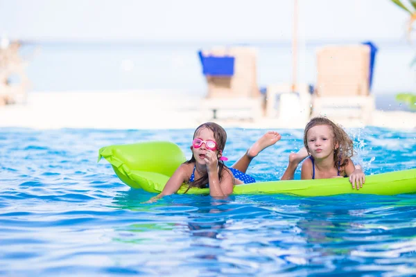 Adorables niñas jugando en la piscina al aire libre de vacaciones —  Fotos de Stock