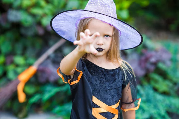 Portrét roztomilá holčička nosit kostým čarodějnice s koštětem na Halloween — Stock fotografie