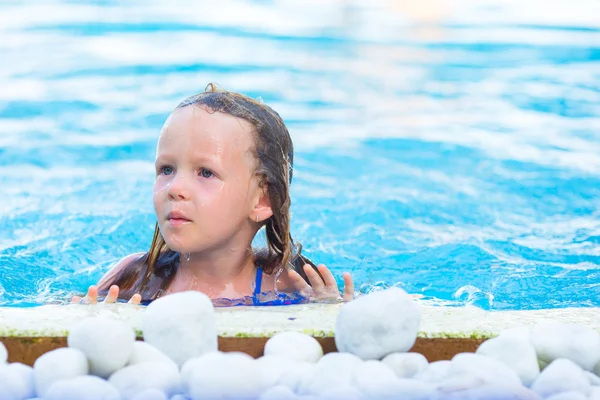 Pequena menina adorável na piscina ao ar livre nas férias de verão — Fotografia de Stock