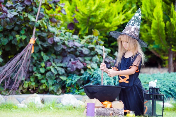 Adorable niña con disfraz de bruja en Halloween en el día de otoño. Truco o trato . — Foto de Stock